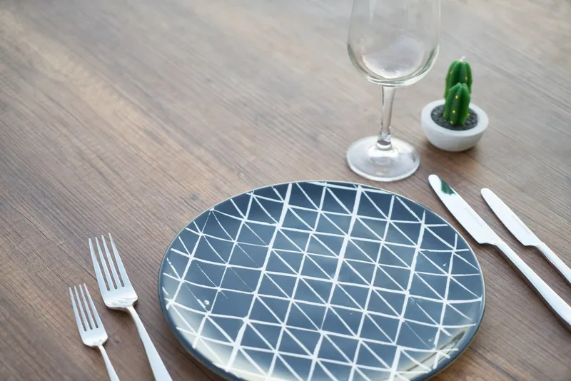 Libro sobre una mesa de madera con una taza y una planta, ambiente de lectura sereno